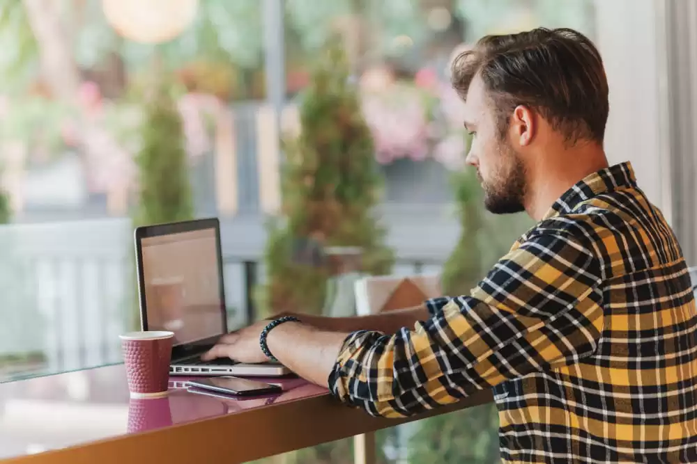 Man using laptop at a cafe